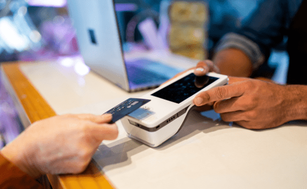 Someone tapping to pay on a card reader.