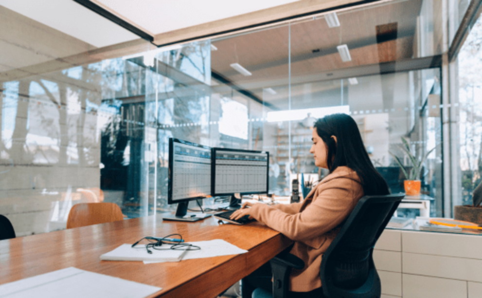 A person sitting at a desk in a corporate office.