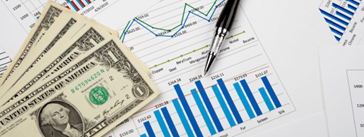 A pen and a stack of $1 bills on top of a research report.