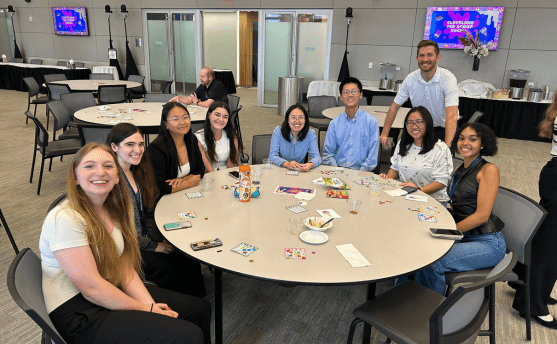 A group of interns sitting around a table in a conference room.