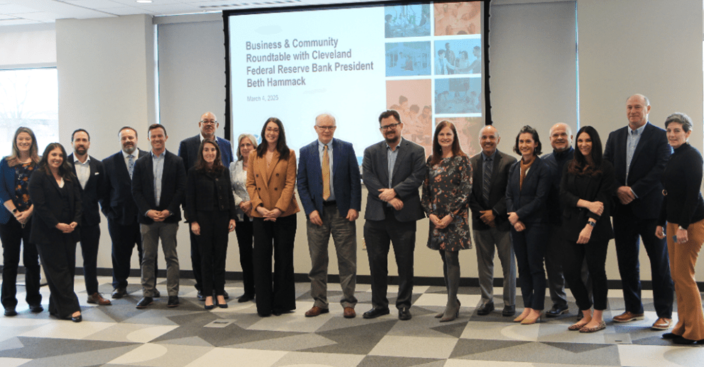 A group of people take a photo in a conference room.