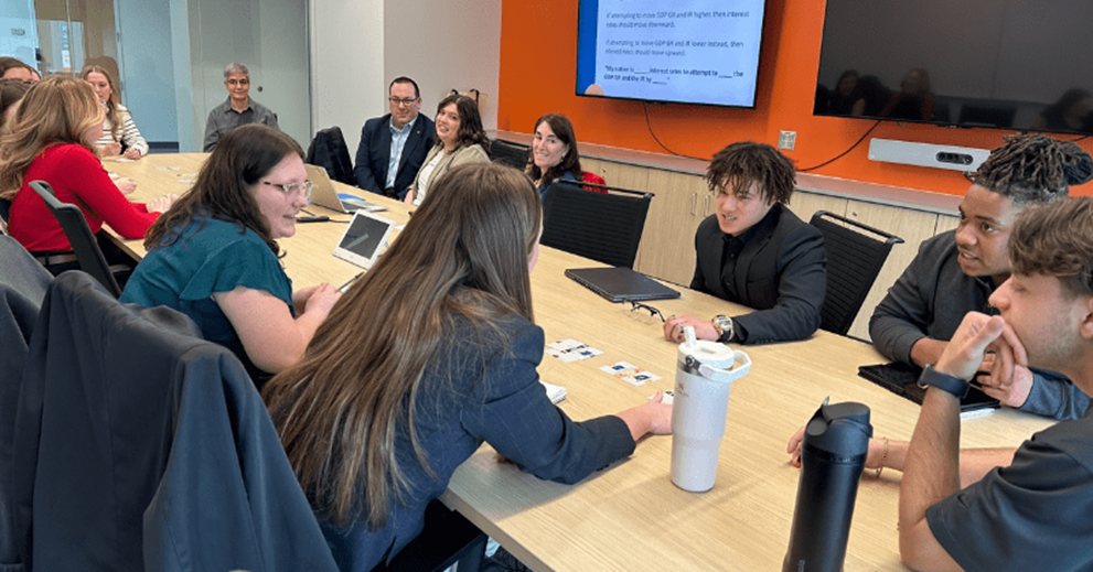 A small group of people talk at a table.