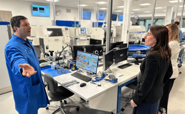 A small group of people talk in a lab setting.
