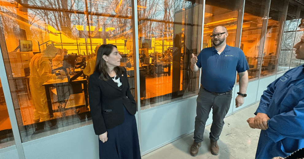 A small group of people talk outside of a lab.