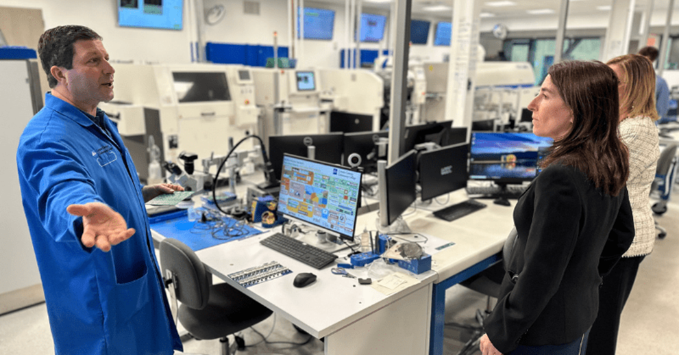 A small group of people talk in a lab setting.