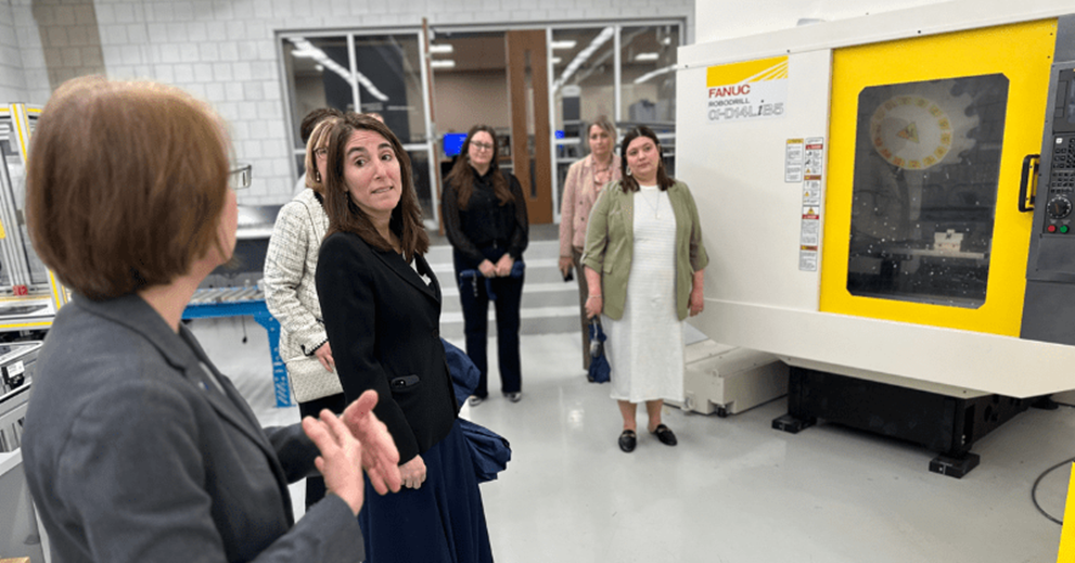 A small group of people talk in a lab setting.