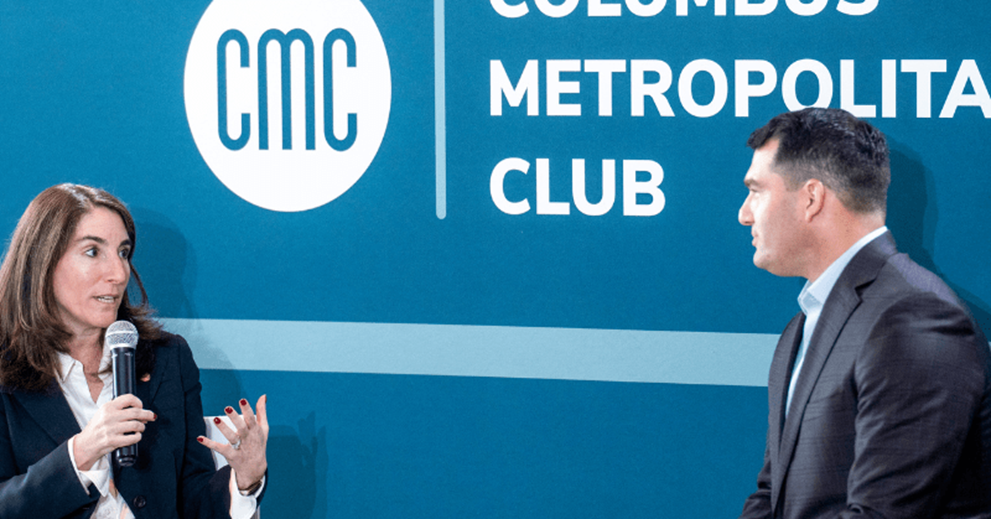 Two people speak on a stage