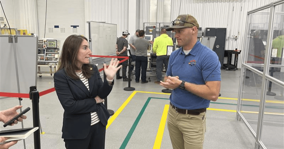A man and a woman talk in a training center where employees are receiving robotics training.