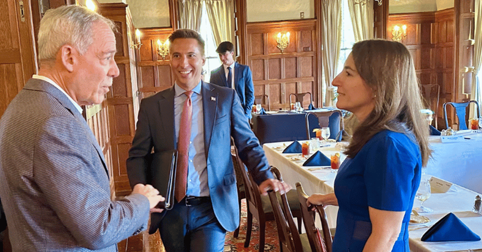 Three people talking in a dining room setting