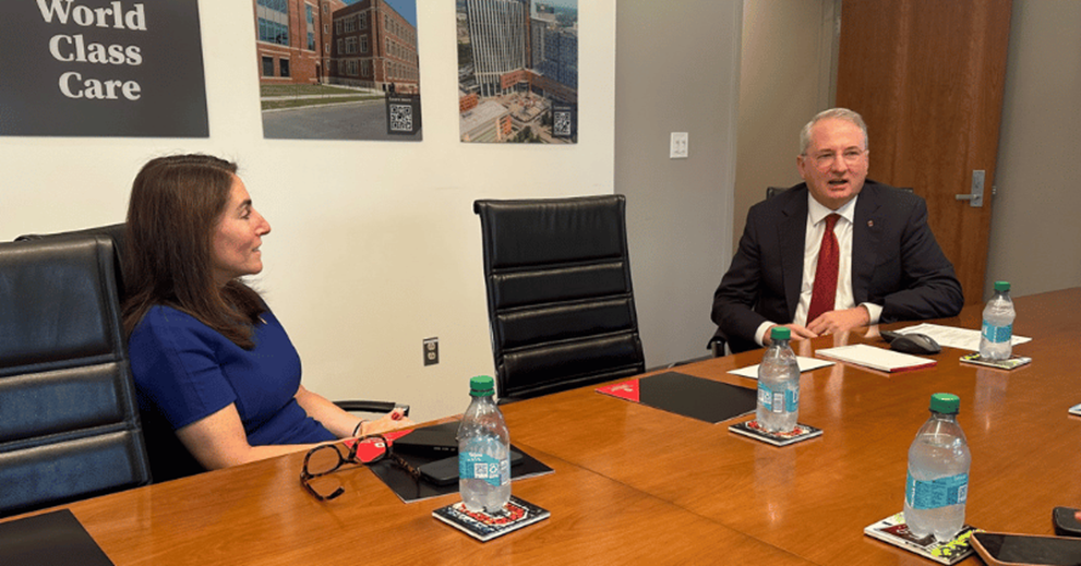 Two people talk in a conference room