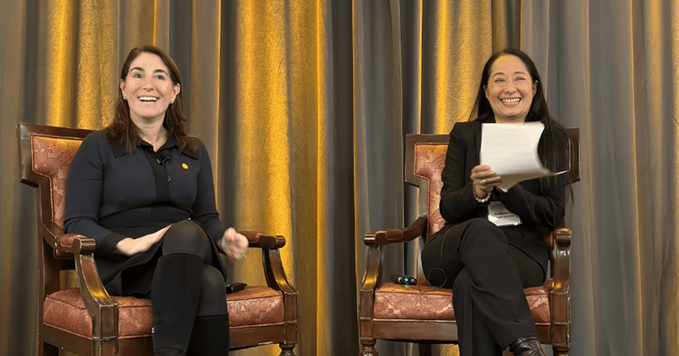 Two people on chairs on a stage