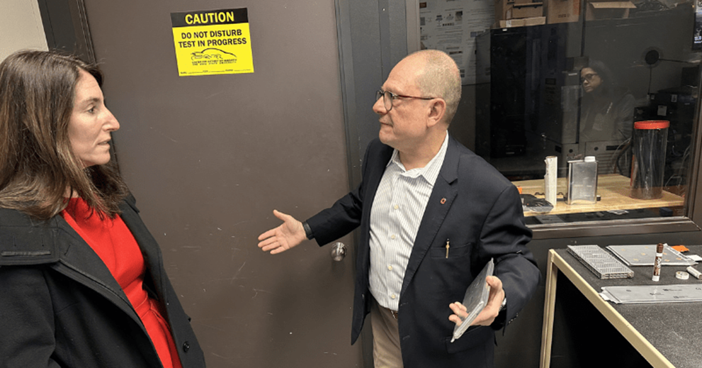 Two people look at a project in factory setting.