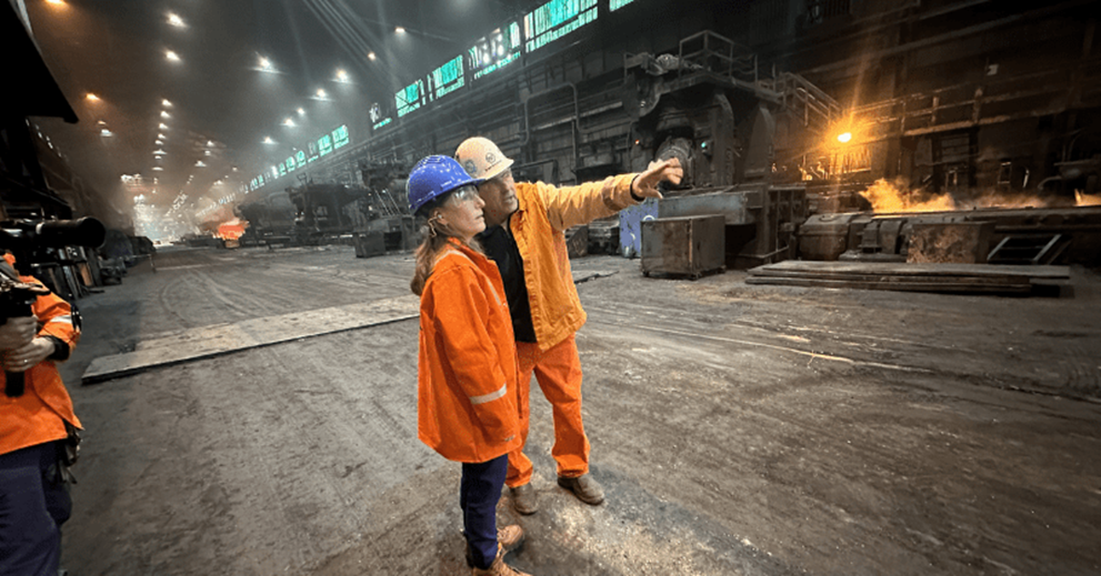 Two people look at a project in a factory setting