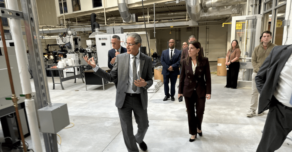 A group of people walk through a laboratory setting.