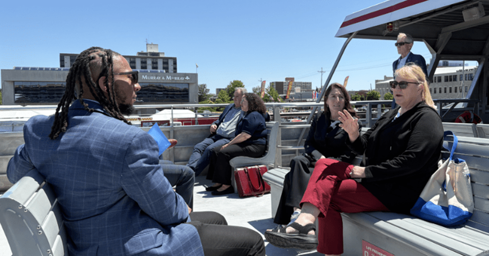 Hammack (center) and Davonta Milbry (left), education outreach coordinator at the Cleveland Fed, chat with Dawn Weinhardt (right), vice president of operations at Shores & Islands Ohio, while on the ferry from downtown Sandusky to Cedar Point.