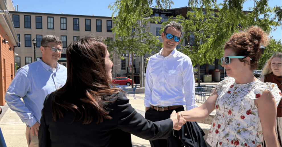 Hammack greets McKenzie Spriggs, senior director of destination management at the Greater Sandusky Partnership. Also pictured, from left to right, are Eric Wobser, chief executive officer at the Greater Sandusky Partnership, and Andrew Bennett from the Cleveland Fed.