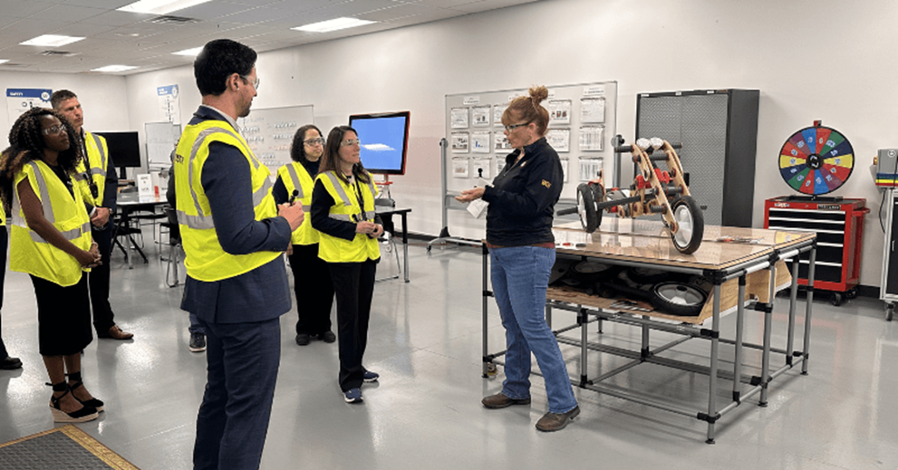 Hammack (second from right) receives a demonstration from Kristin Day (far right), vice president of US manufacturing at Whirlpool. Also with Hammack are two Cleveland Fed colleagues: Brian Anderson (center), regional executive, and Ericka Thoms (third from right), senior government relations liaison.