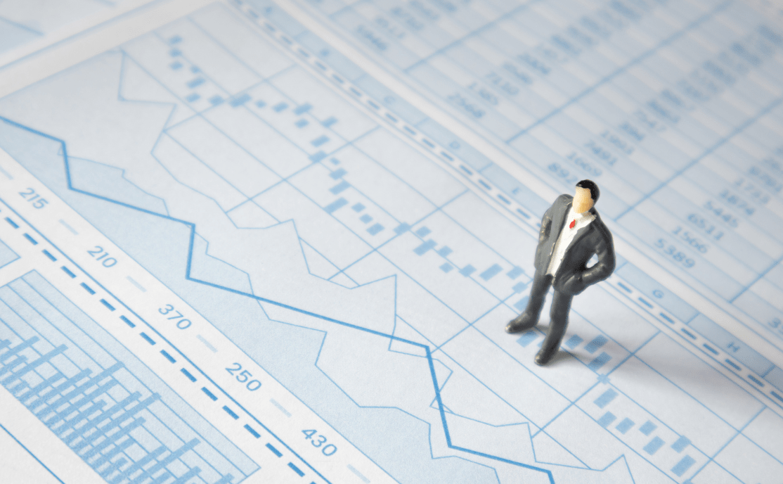 A figure of a man standing on financial data.
