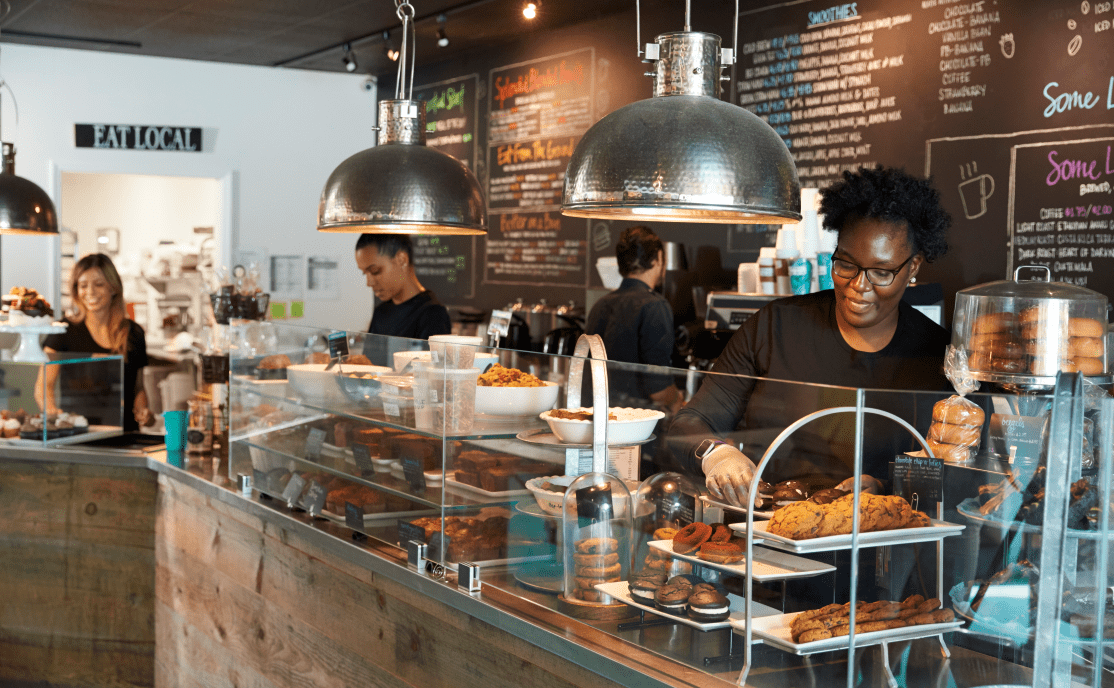 Four employees working behind the counter at a cafe.