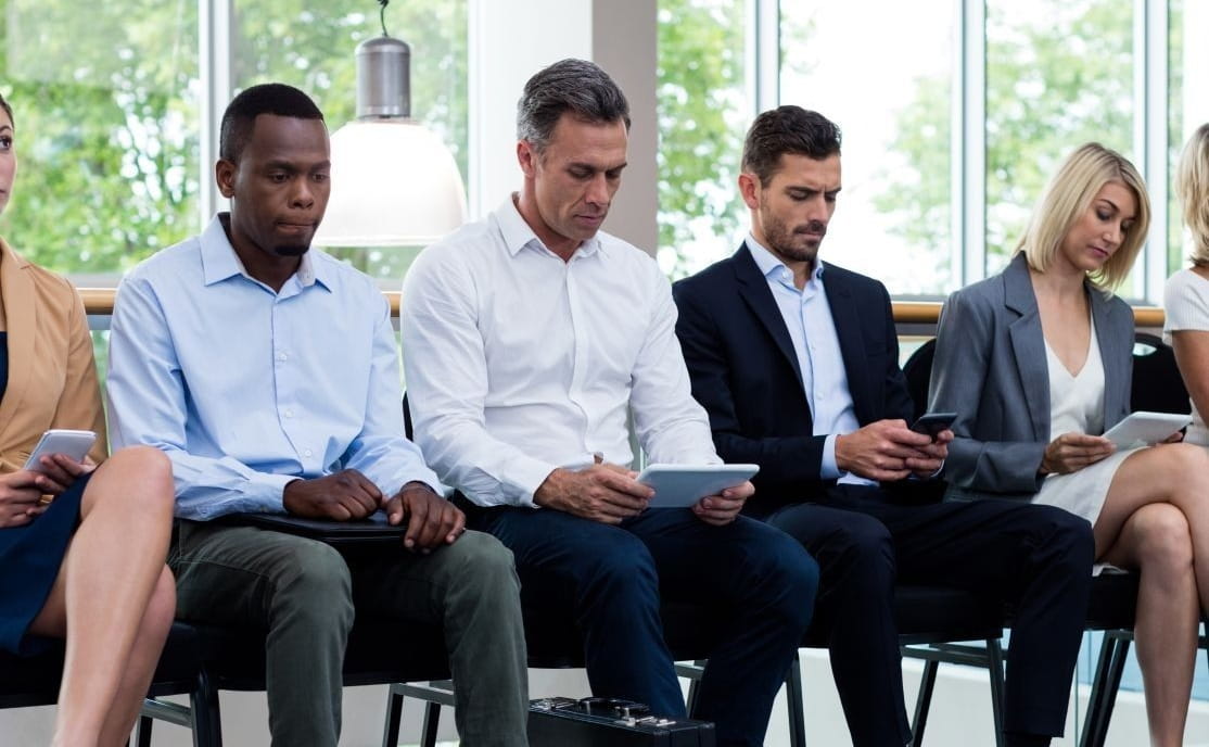A group of professionals waiting in a lobby.