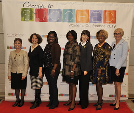 Speakers and panelists join together for a group photo.