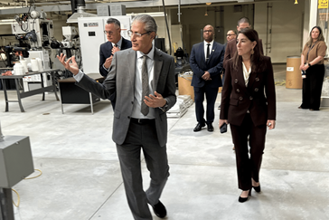 A group of people walk through a laboratory setting.