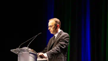 Edward S. Knotek II, Senior Vice President and Director of Research, giving a speech at a podium.