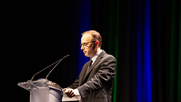Edward S. Knotek II, Senior Vice President and Director of Research, giving a speech at a podium.