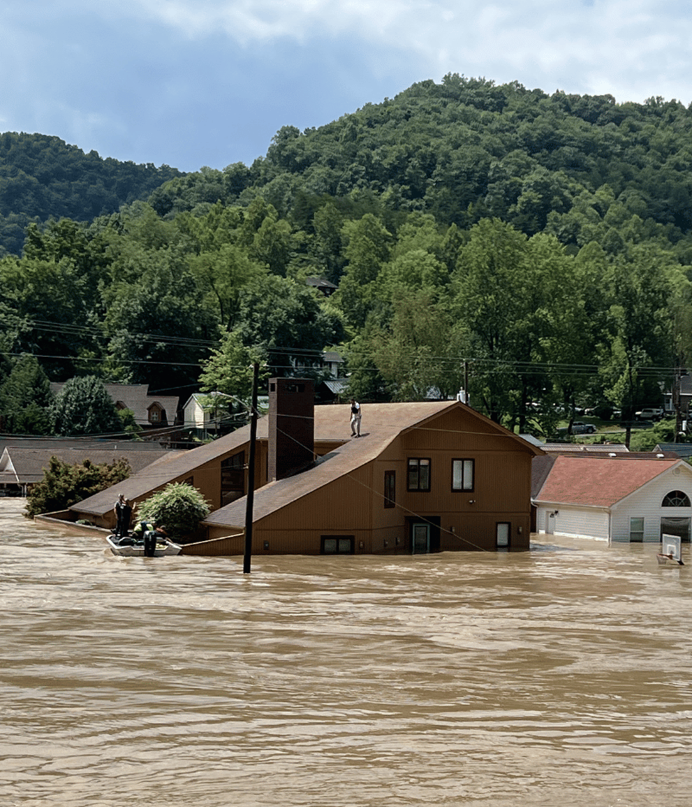 A rescue boat is needed to retrieve a man stranded on the roof of his home.