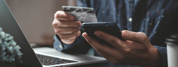 Someone holding a phone and a credit card.